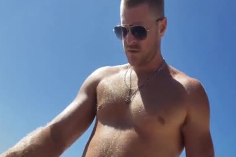 dark And White homosexual On A Public Beach. Interracial Outdoor